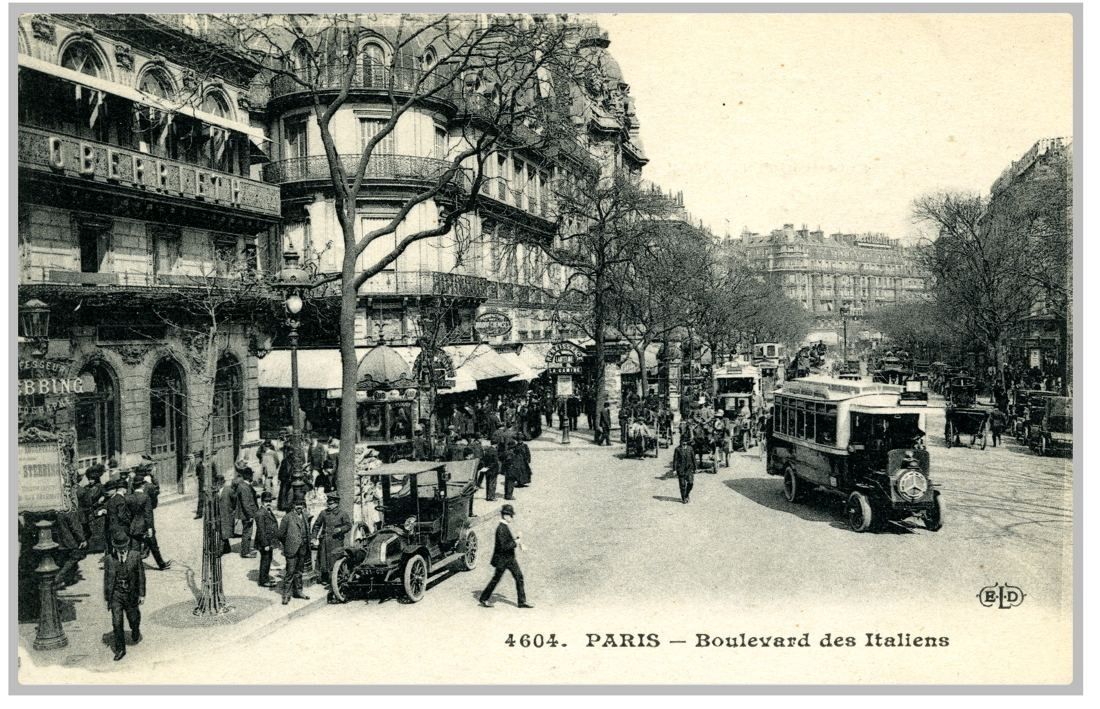 Old postcard of a busy tree-lined boulevard with early cars and buses