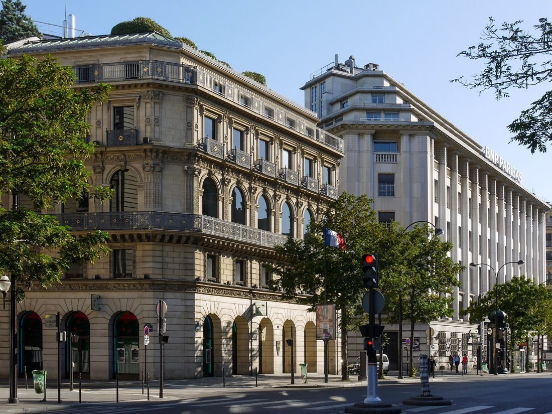 BNP Paribas: Ornate 19th-century corner building next to the pale Art Deco head office on a tree-lined boulevard