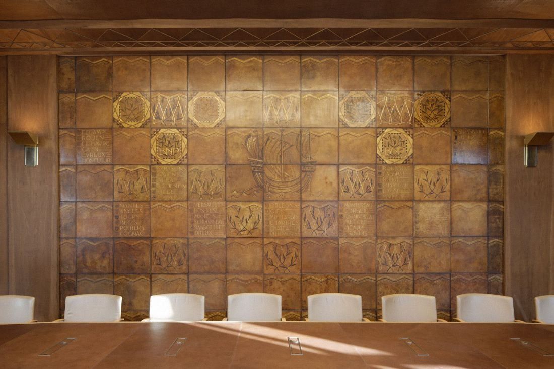 BNP Paribas: Wall of gilded square panels behind a row of white chairs