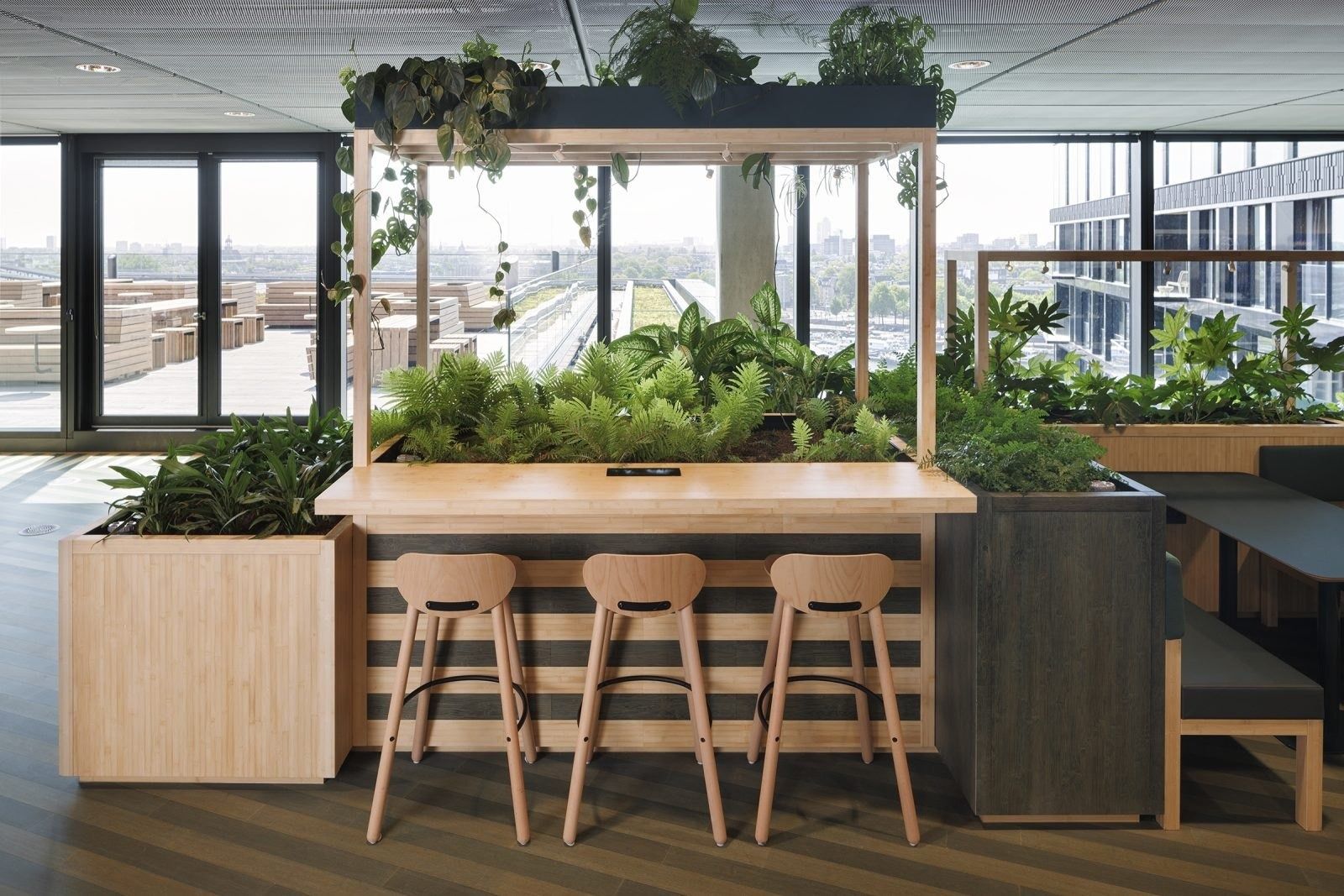 Booking Holdings: Bar counter with stools and a planter frame by a window
