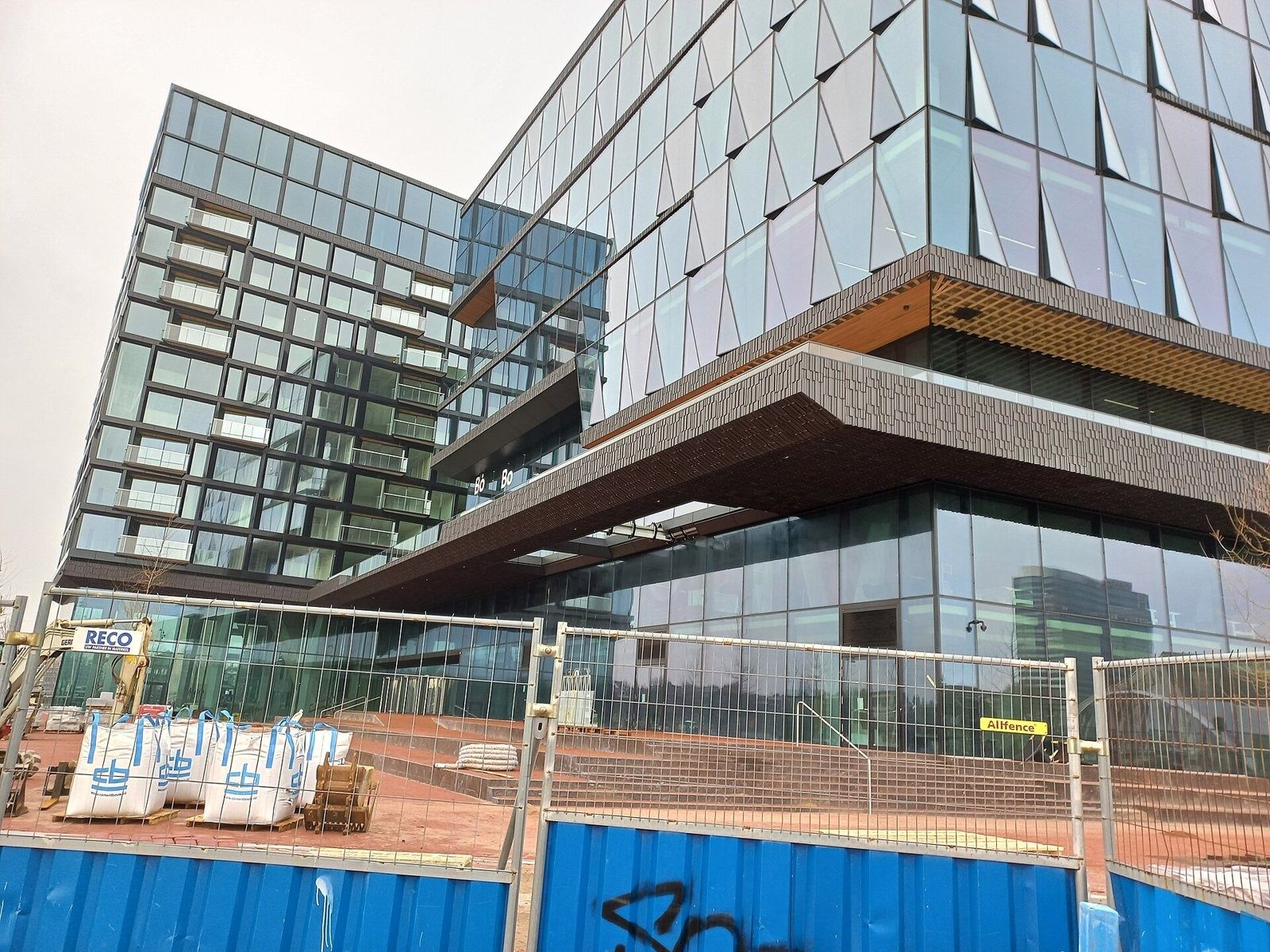 Campus building under construction behind site fences