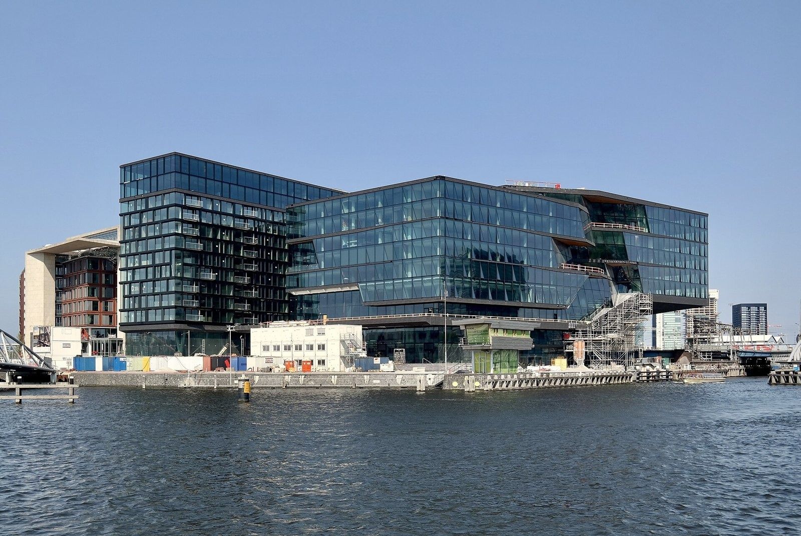 Booking Holdings: Glass campus building seen from across the harbour