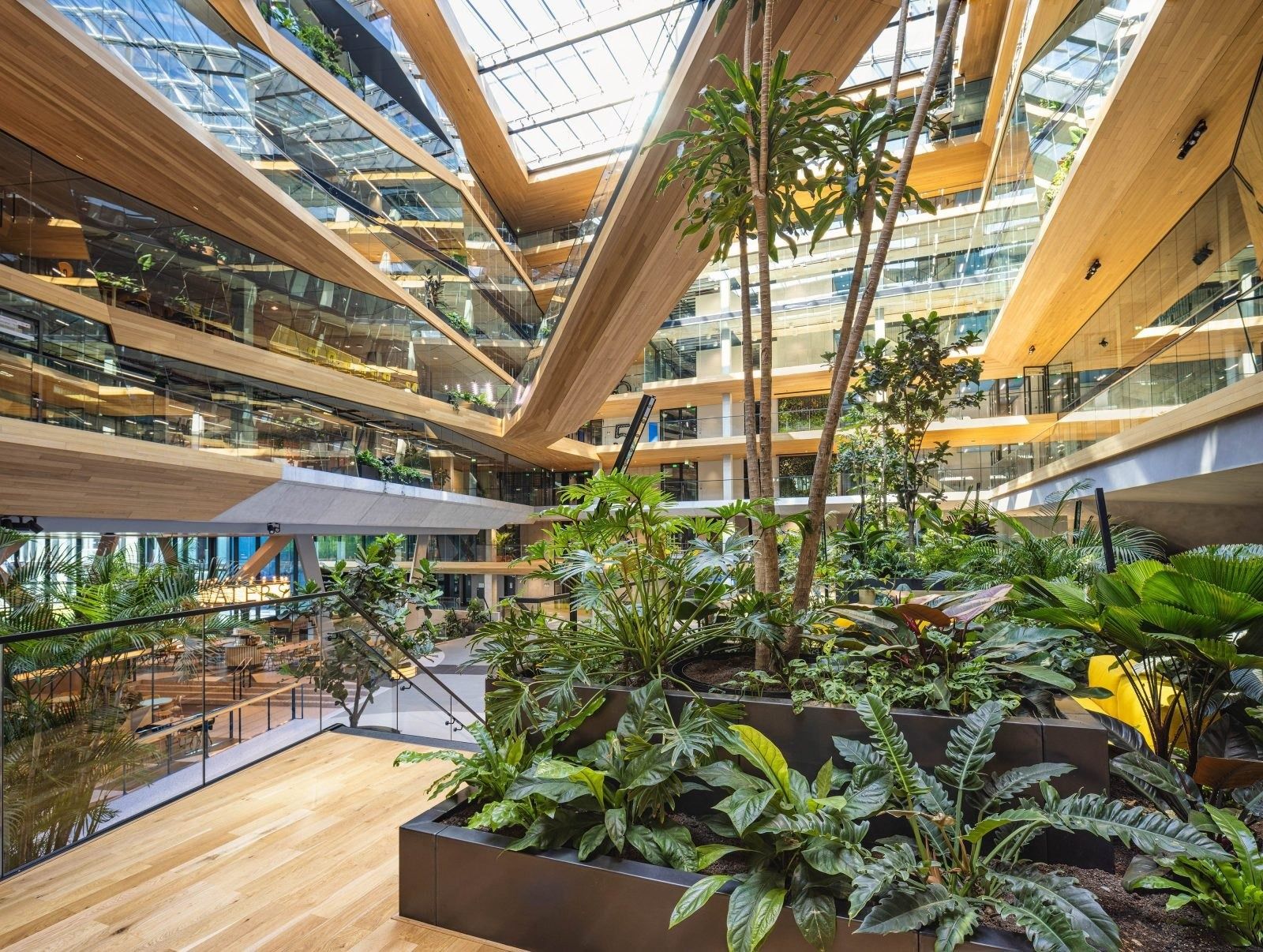 Booking Holdings: Plant-filled atrium with timber-clad balconies under a glass roof