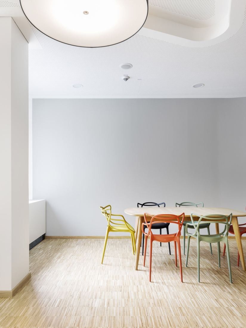 Bosch: Small room with a wooden table and colourful chairs under a round pendant lamp