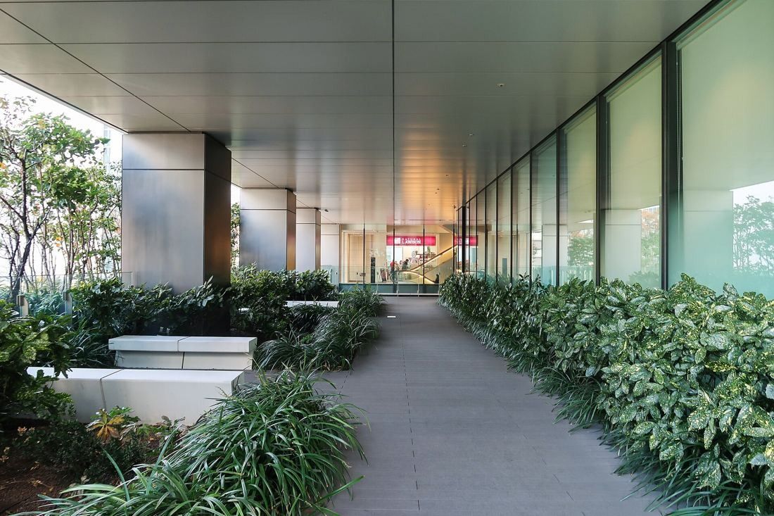 Bridgestone: A planted walkway under the building's overhang on an upper podium level