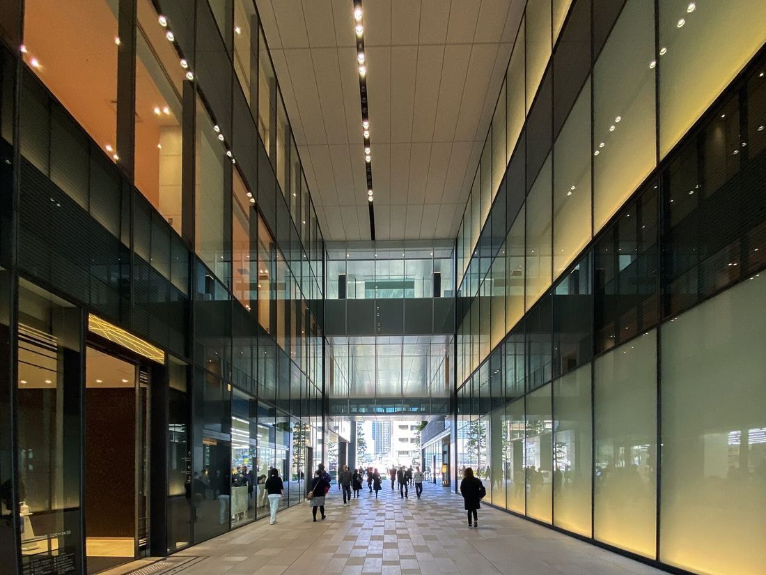 Bridgestone: A tall, glass-walled passage running through the building with people walking in the distance