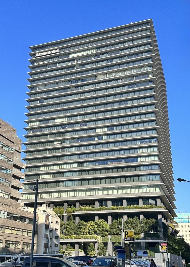 Bridgestone: The full height of the tower with greenery on its lower levels, seen from a street corner
