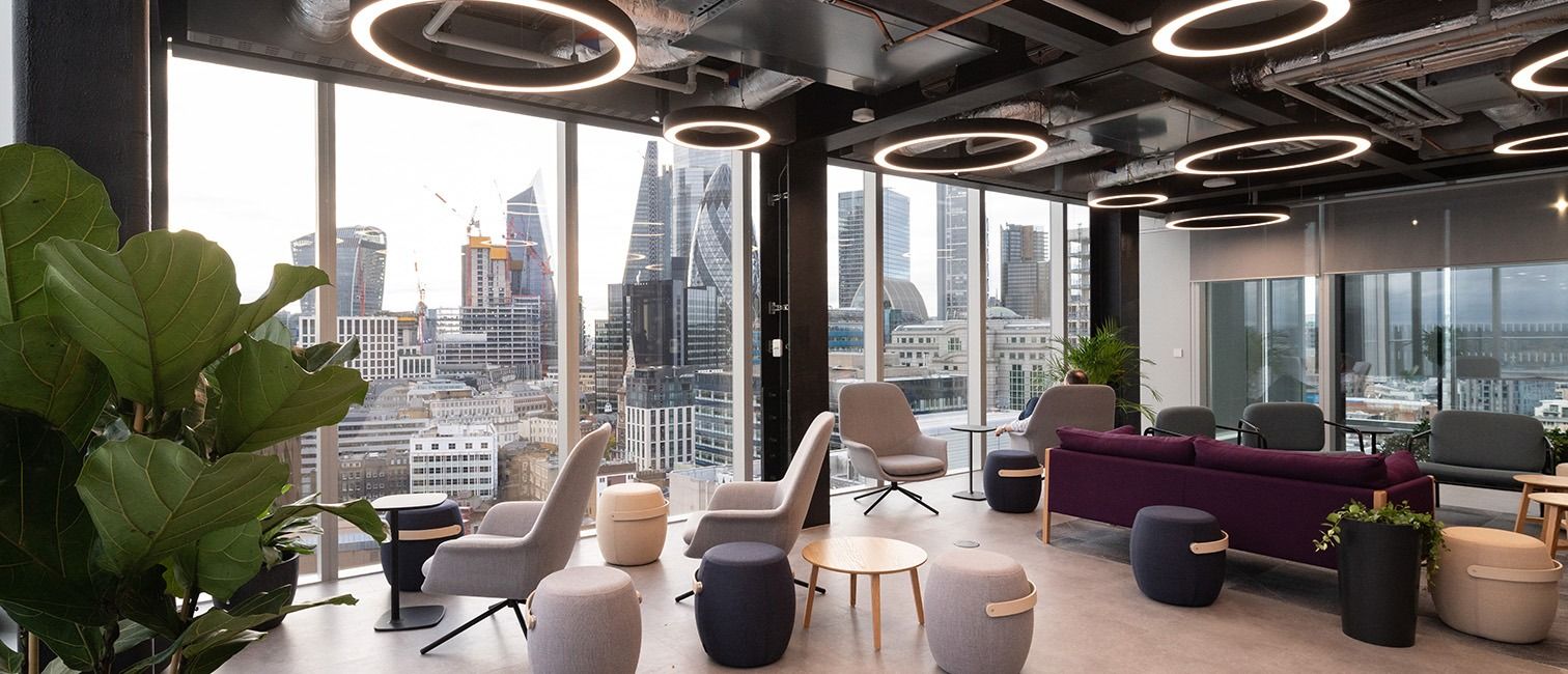 BT Group: Lounge with armchairs by full-height windows facing the City