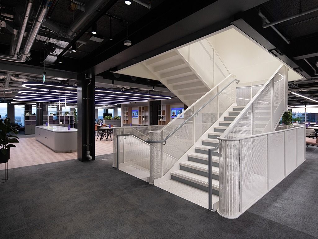 BT Group: White feature staircase rising through an open office floor