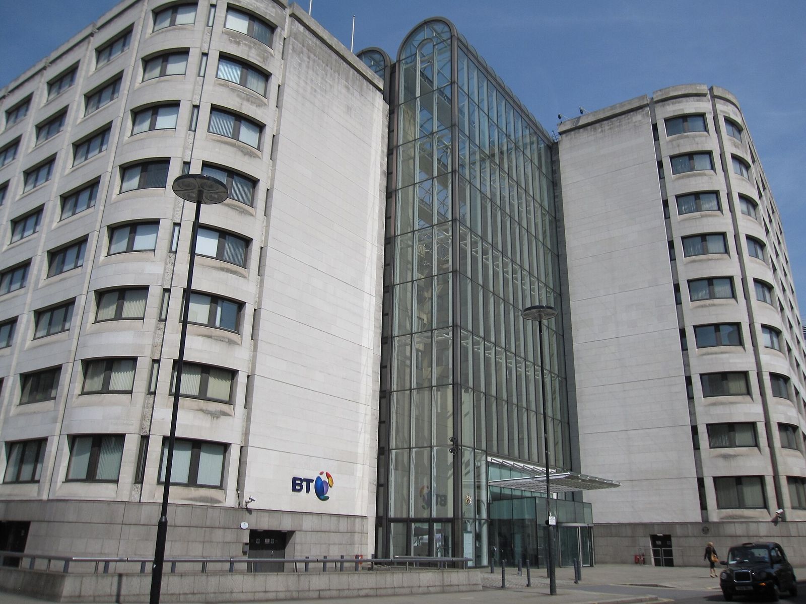 White stone office building with a glass centre and the BT logo