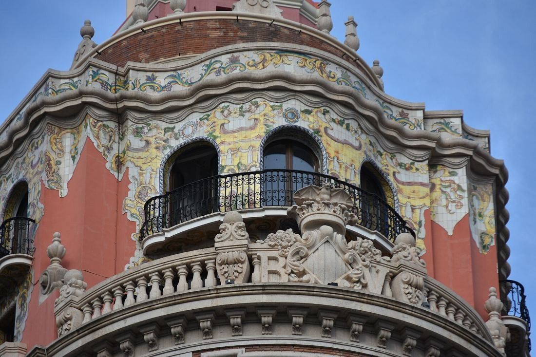 CaixaBank: Detail of curved balconies and decorated pink-and-cream panels