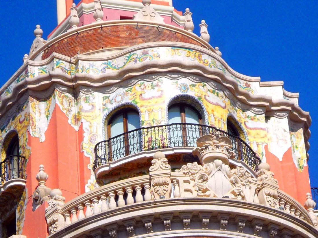 CaixaBank: Ornate curved balcony with colourful decoration under a deep blue sky