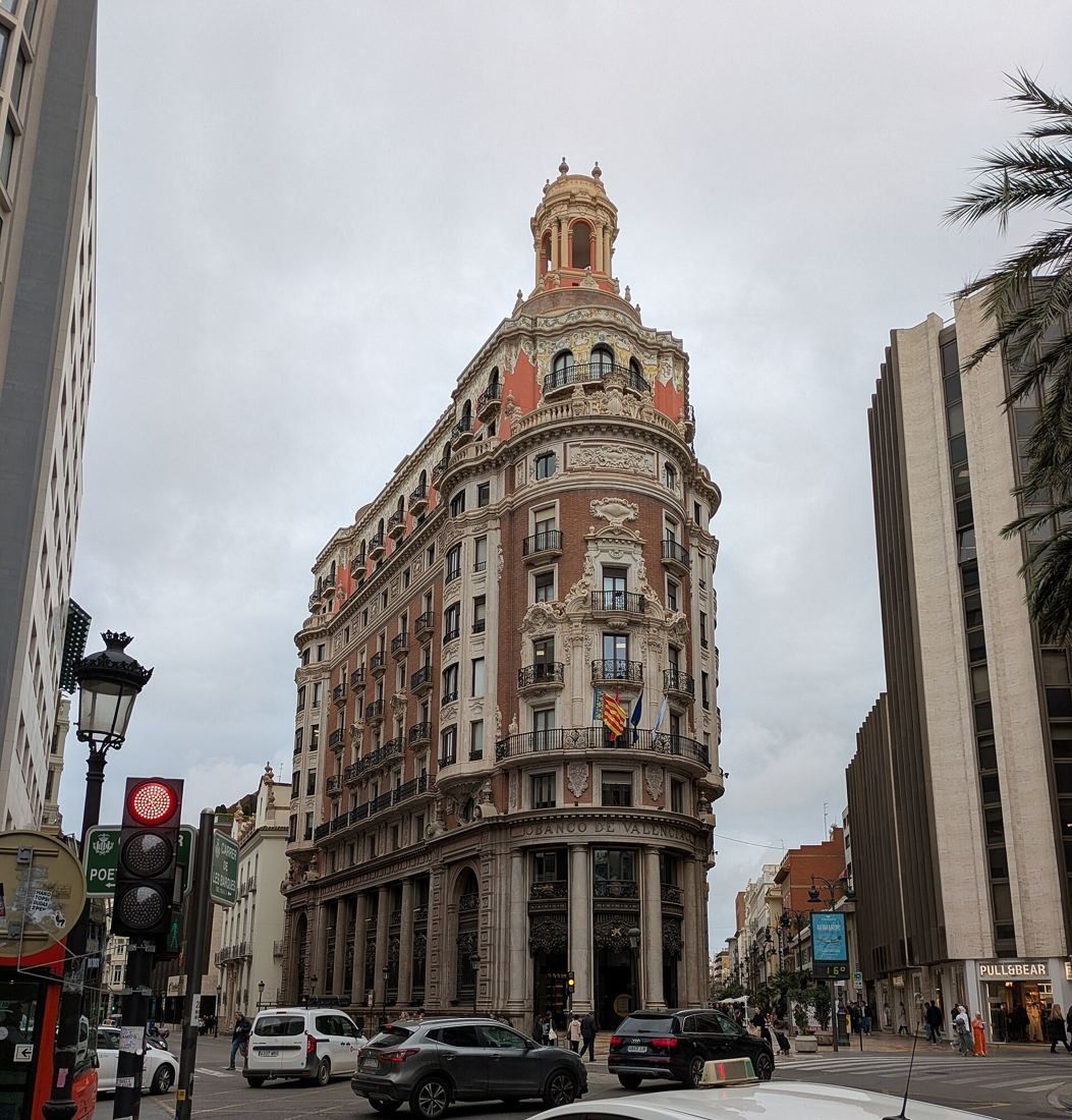 CaixaBank: The corner building on a grey day with traffic lights in the foreground