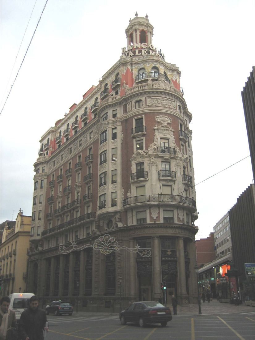 CaixaBank: The corner building on an overcast day with cars passing below