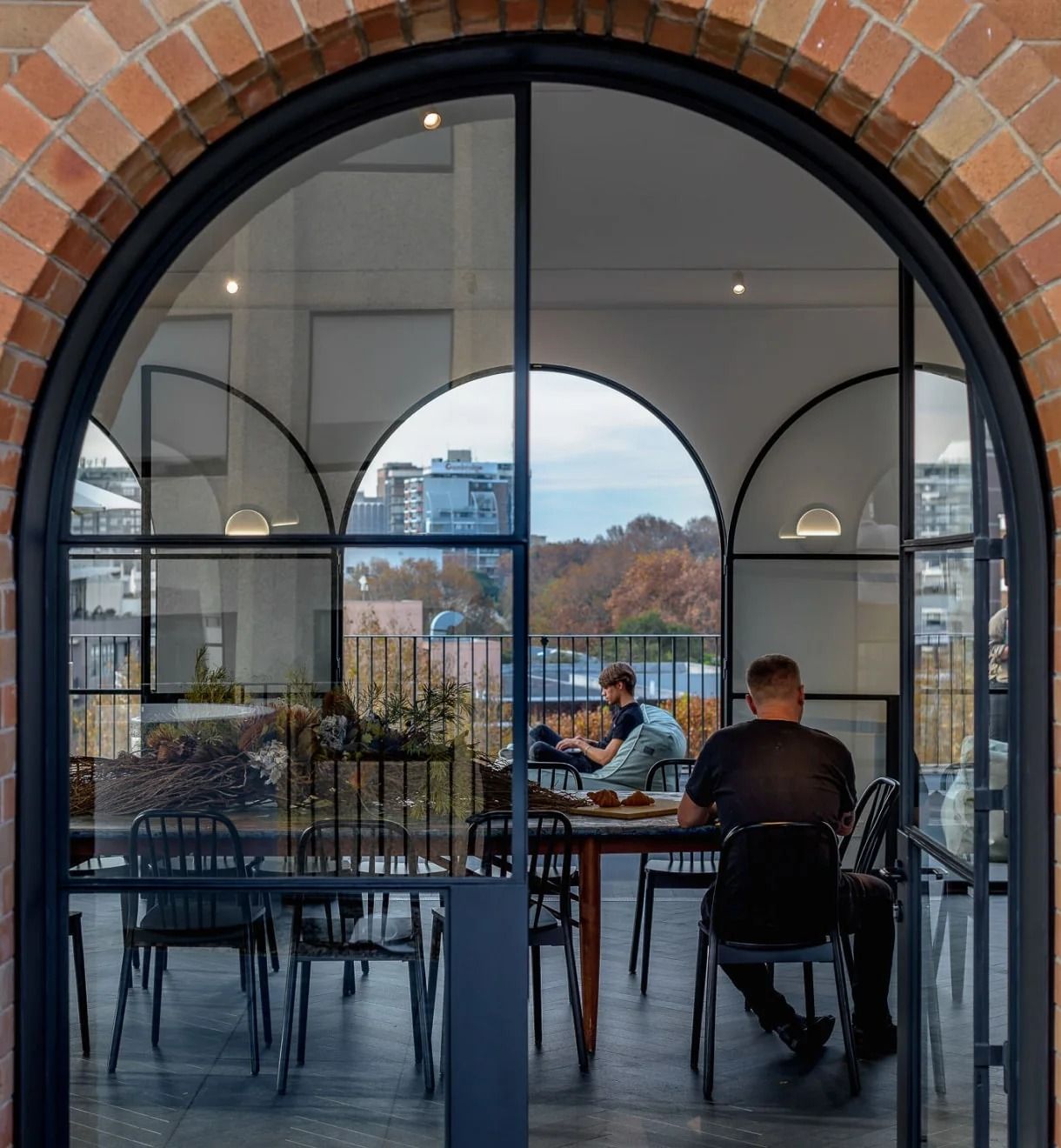 Canva: Arched steel-framed doorway into a dining area