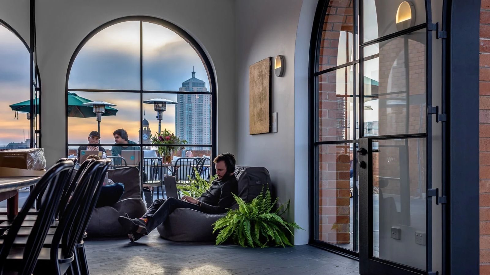 Canva: Lounge by a tall arched window with city views