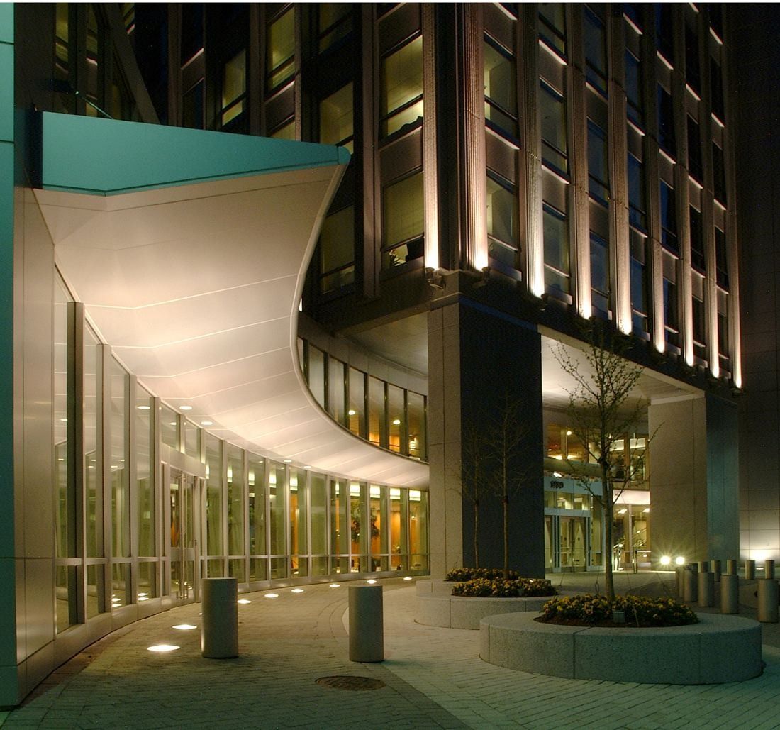 Capital One: Curved metal canopy over a lit building entrance at dusk