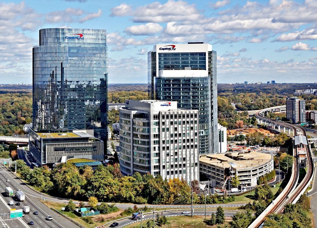 Capital One: Group of glass and white towers beside a highway in autumn