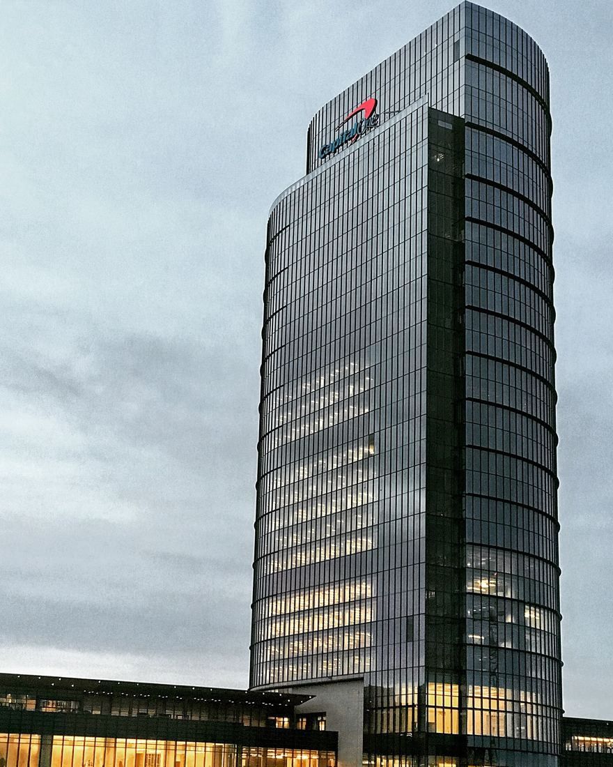Capital One: Slender curved glass tower against a pale sky