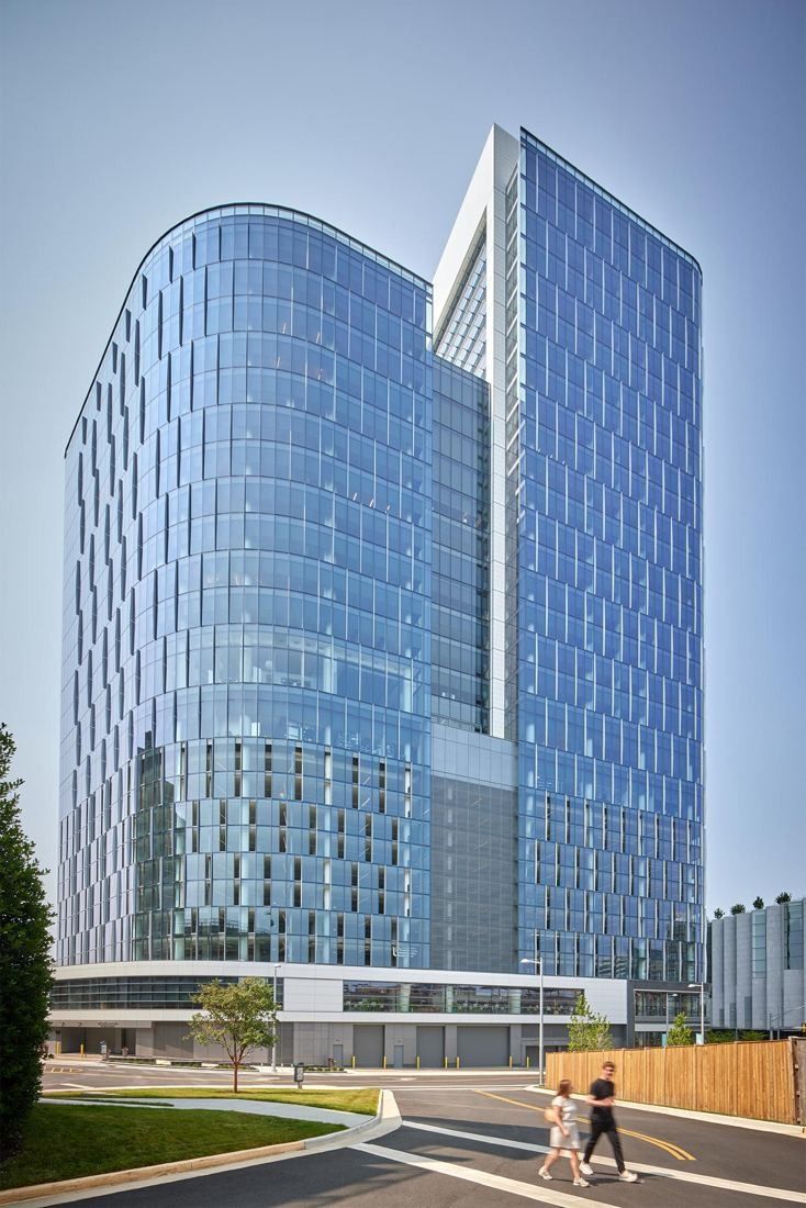 Capital One: Two glass office towers, one curved, above a street with trees