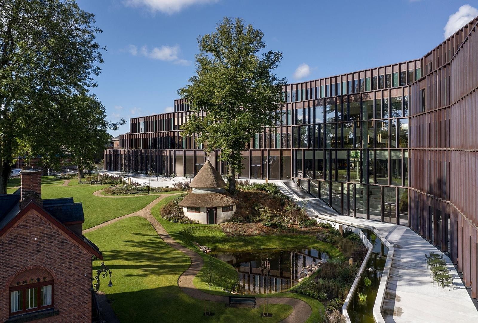 Carlsberg: Copper-clad wings wrapping around a landscaped garden with lawns, paths and a thatched pavilion