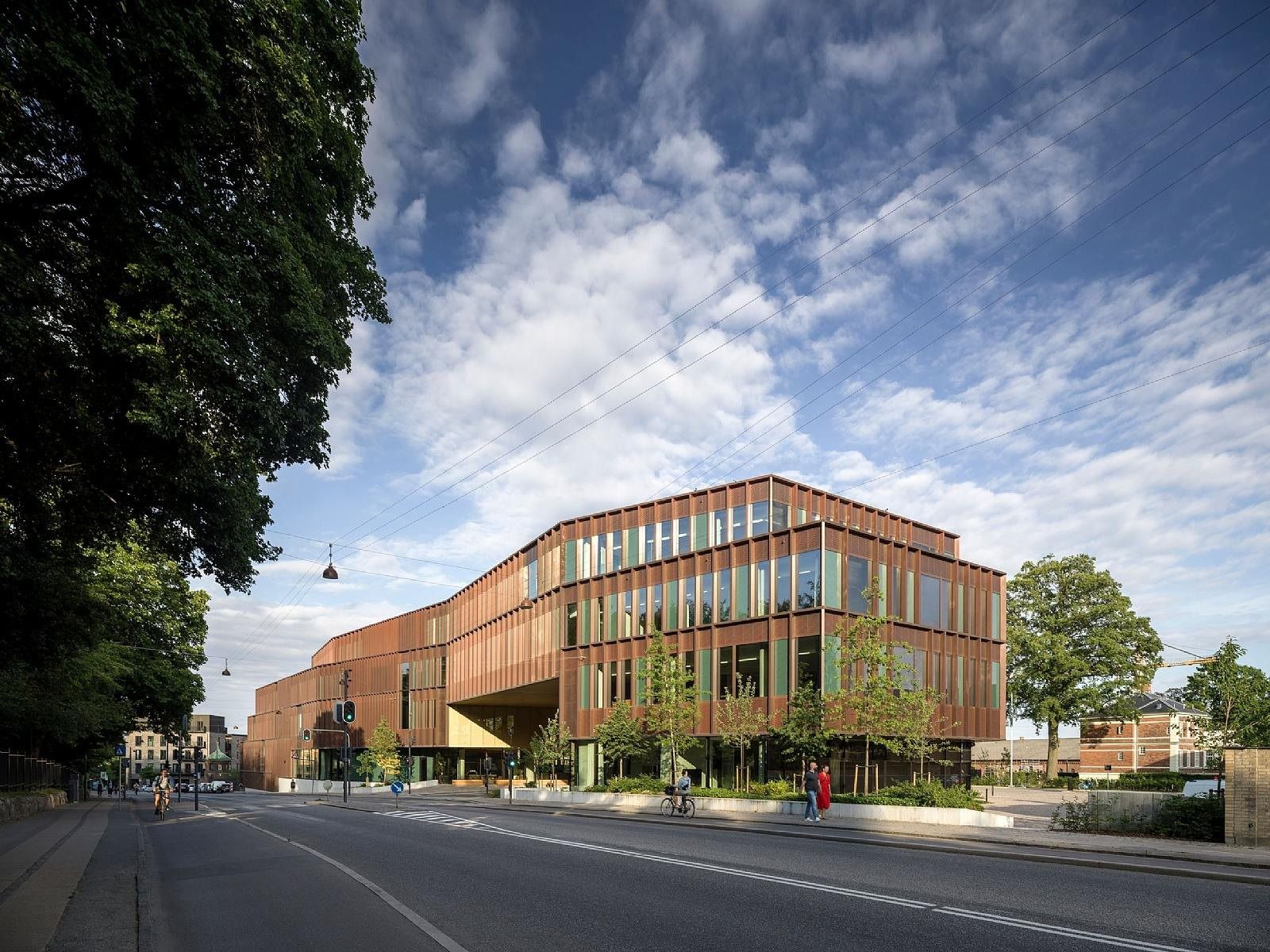 Carlsberg: Curved copper-coloured building seen across a street under a blue sky