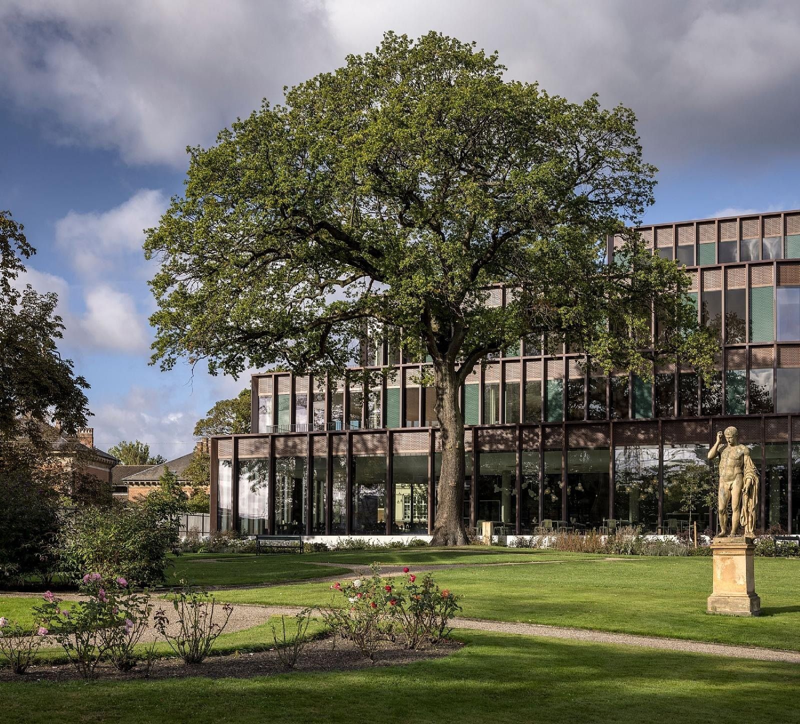 Carlsberg: Large tree and statue in a garden in front of the copper-coloured façade