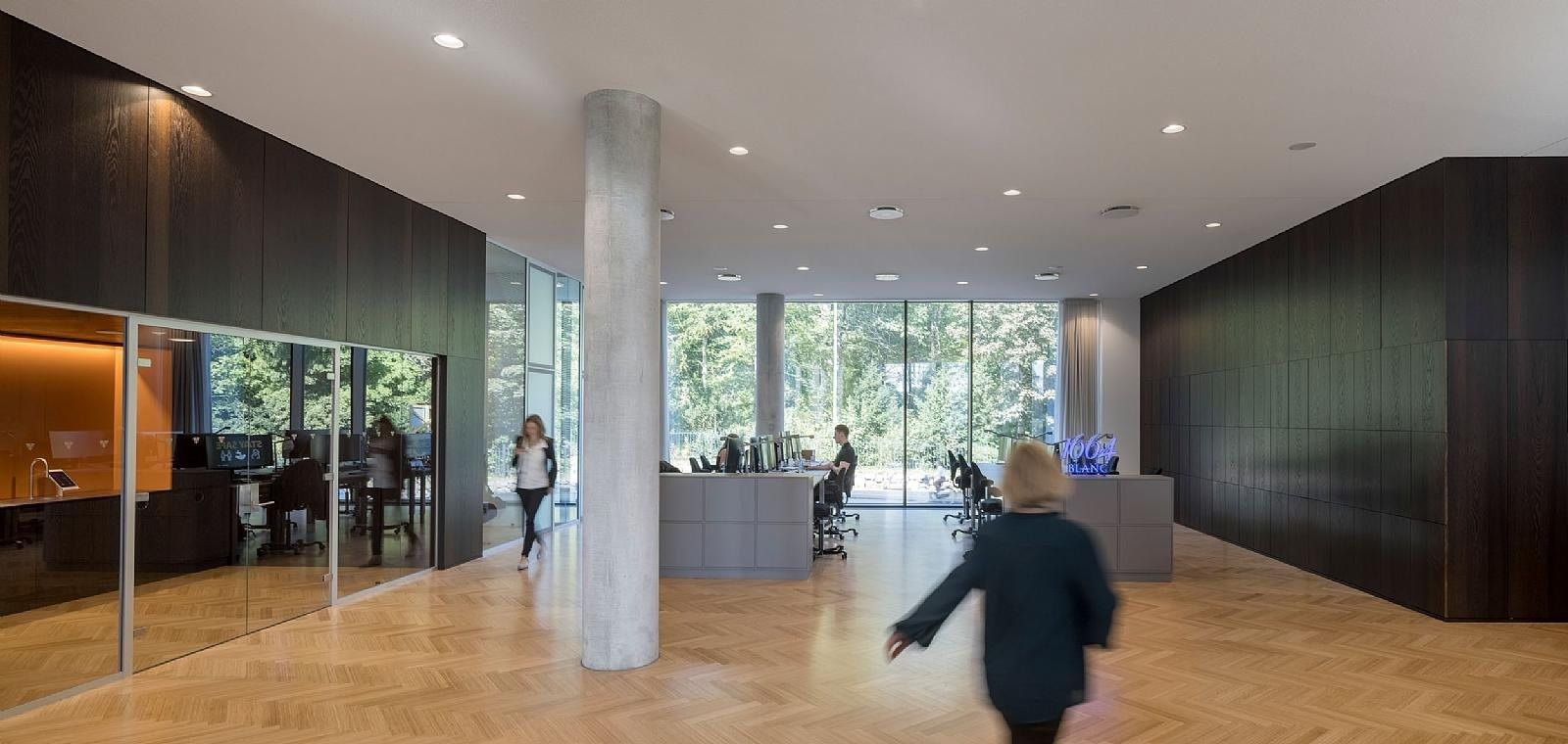Carlsberg: Office floor with herringbone wood floor, concrete column, dark wood walls and desks by the windows
