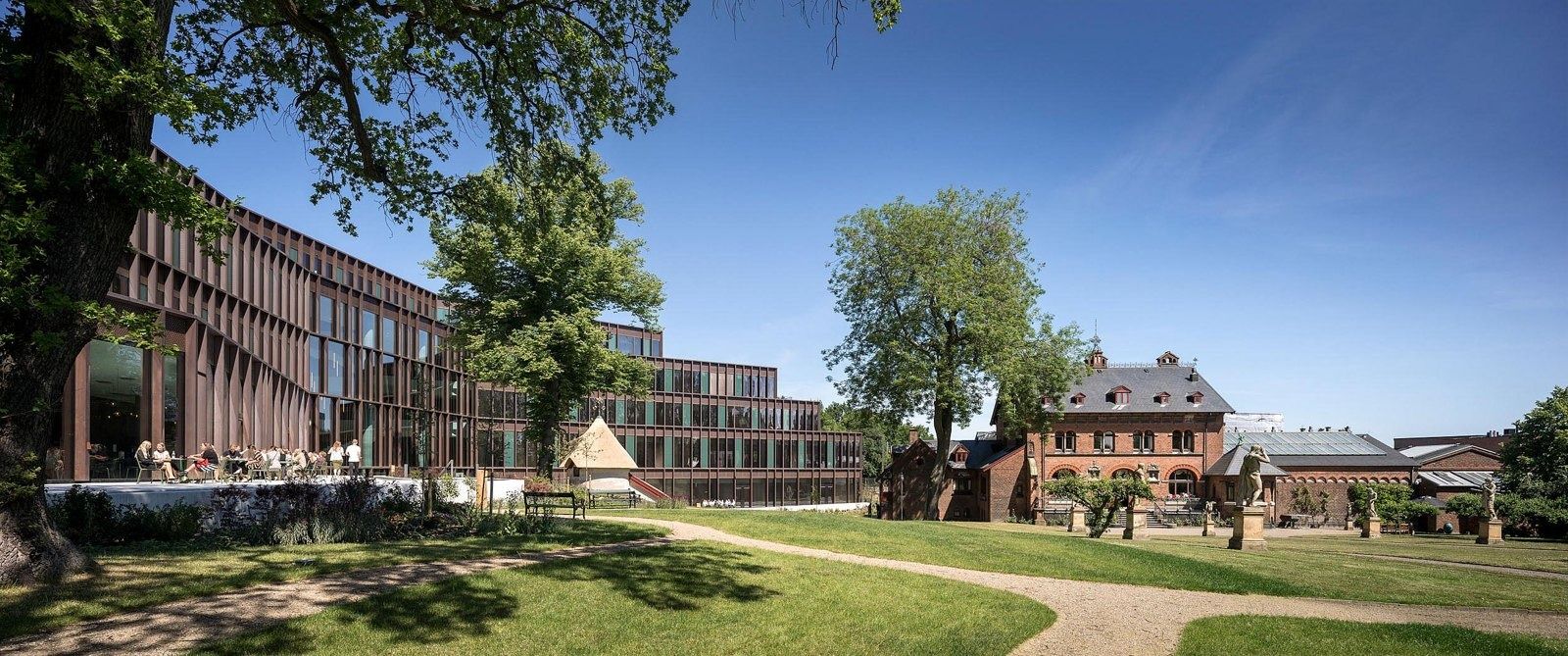 Carlsberg: Panorama of a lawn and trees with the copper-coloured building and a red brick house