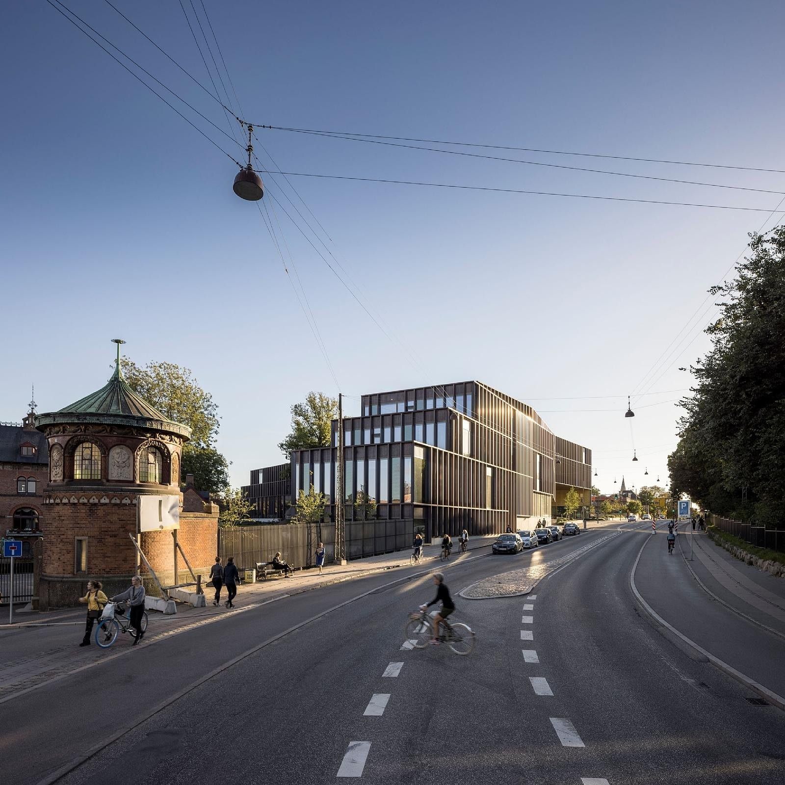 Carlsberg: Street view with the copper-coloured building in the distance and a historic brick tower