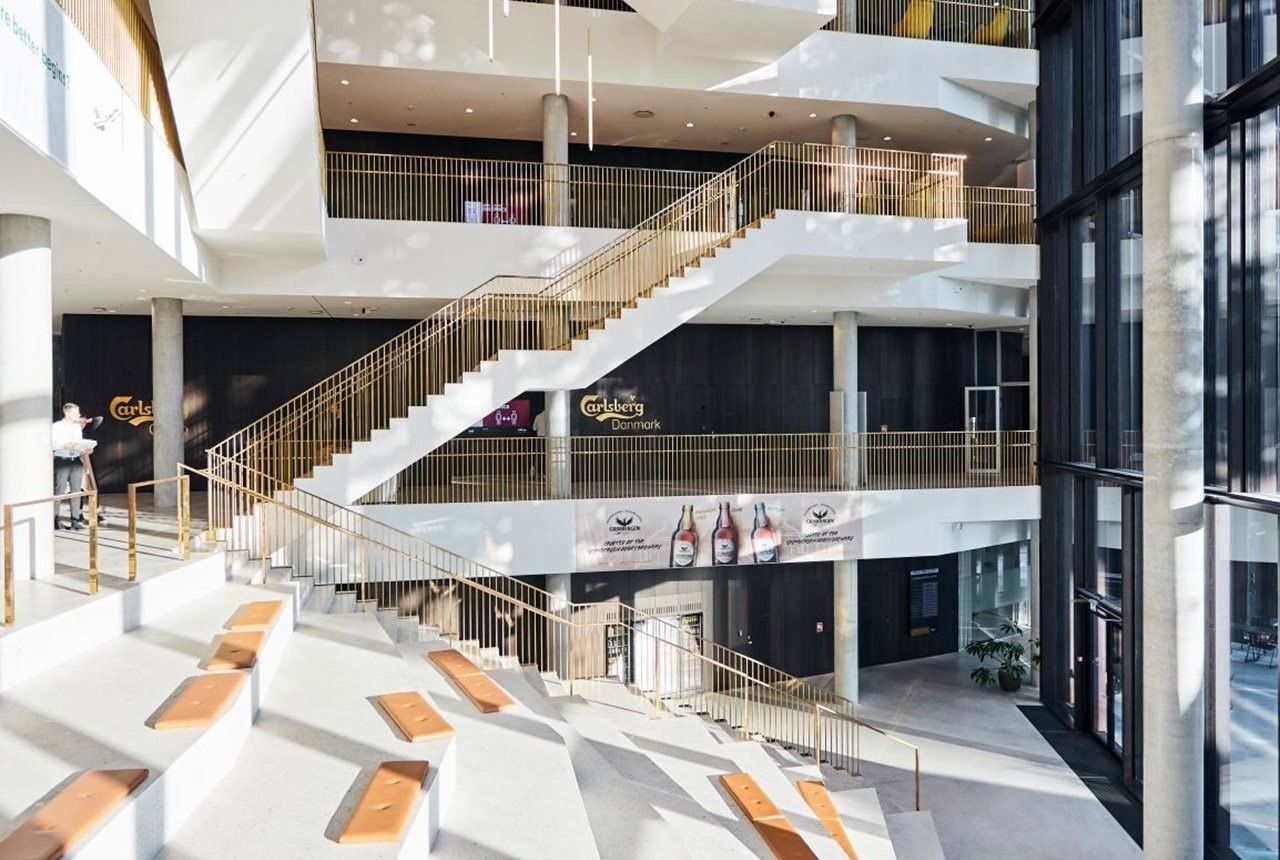 Carlsberg: White staircase with brass railings rising through the open atrium