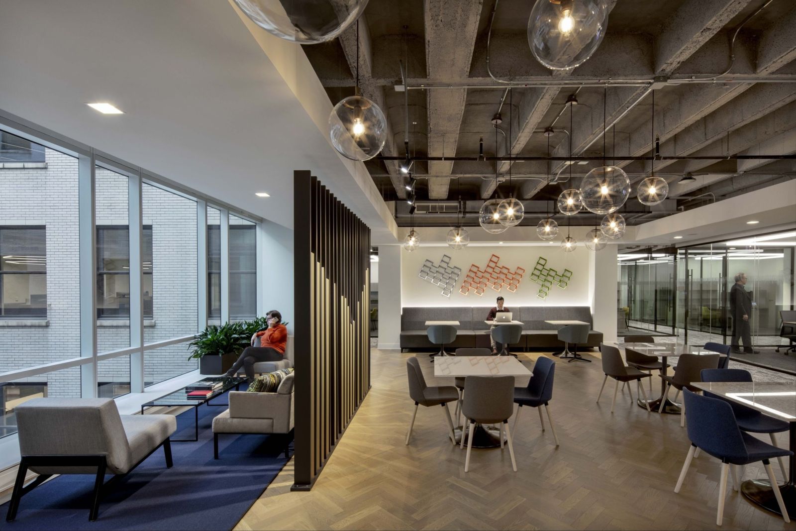 Cboe Global Markets: A café with round tables and a slatted wood screen under hanging glass globes
