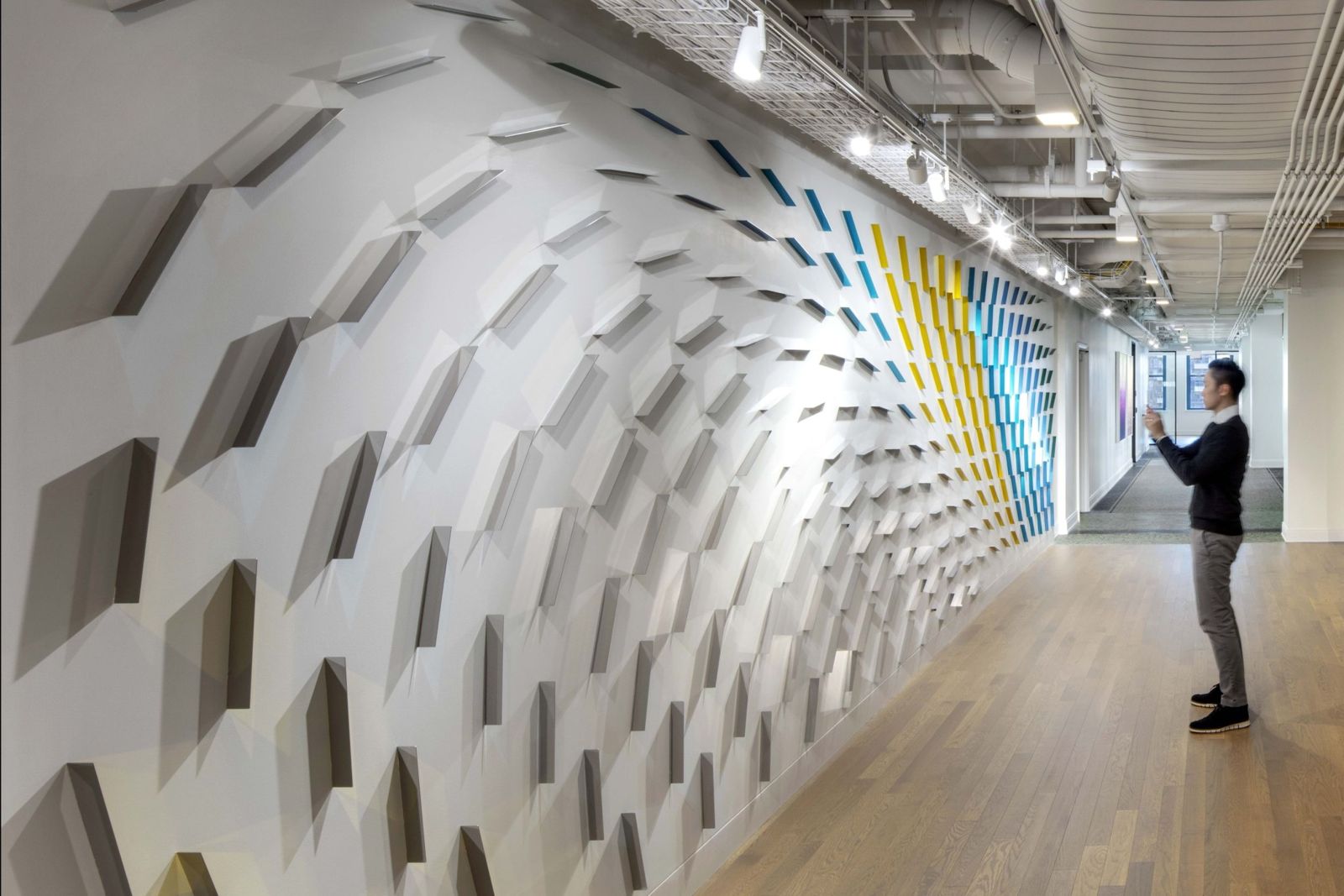 Cboe Global Markets: A long corridor wall of sculpted white panels shading into stripes of colour