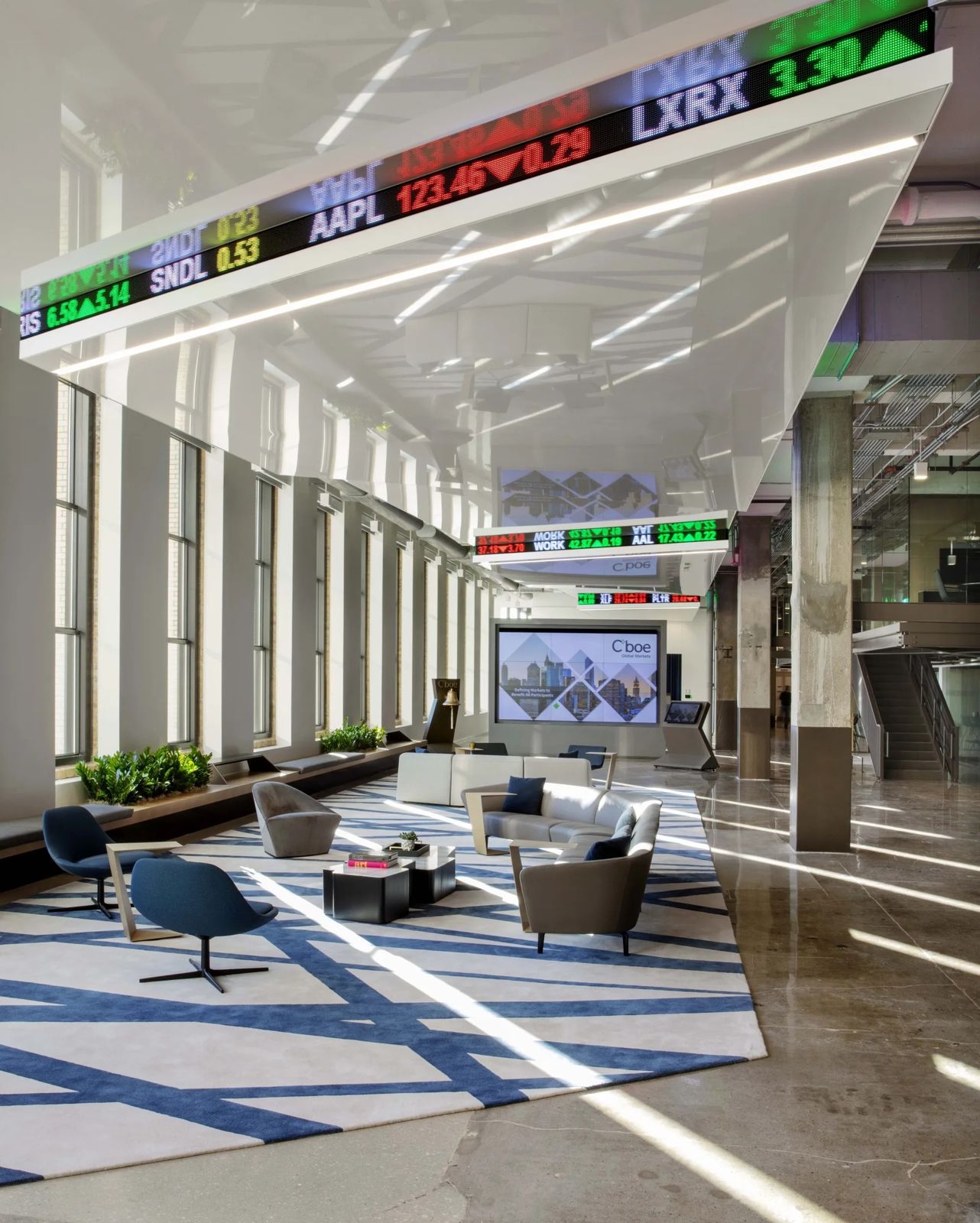 Cboe Global Markets: A long lounge under a tickering ceiling, with blue rugs and armchairs