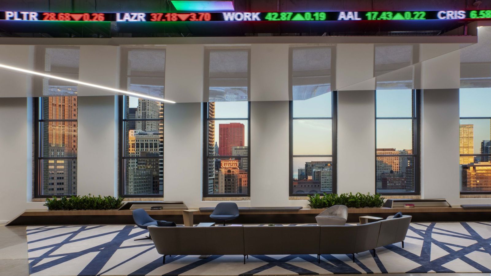 Cboe Global Markets: Curved sofas beneath tall windows with the Chicago skyline at dusk