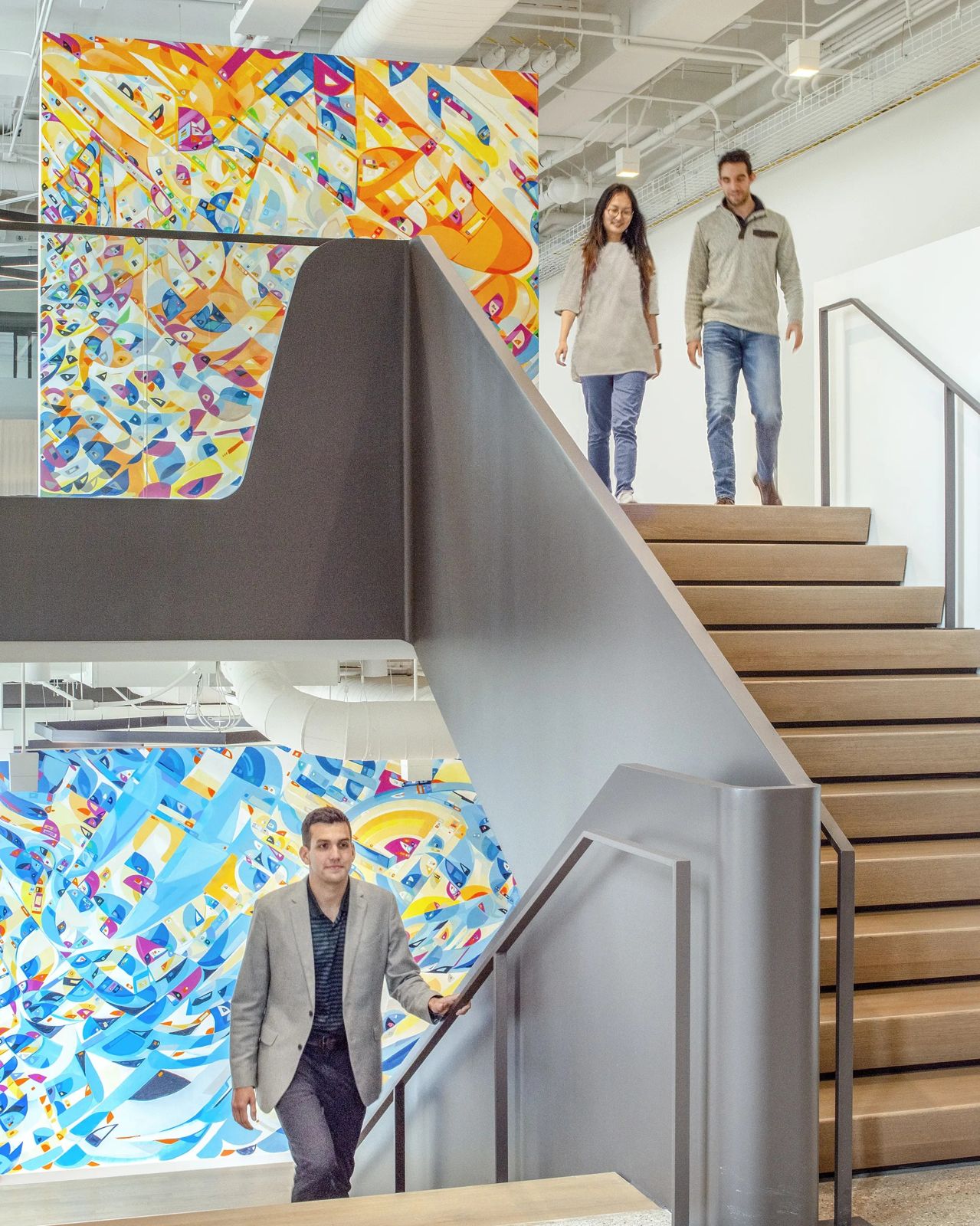 Cboe Global Markets: Two people walking down a stair between bright geometric murals