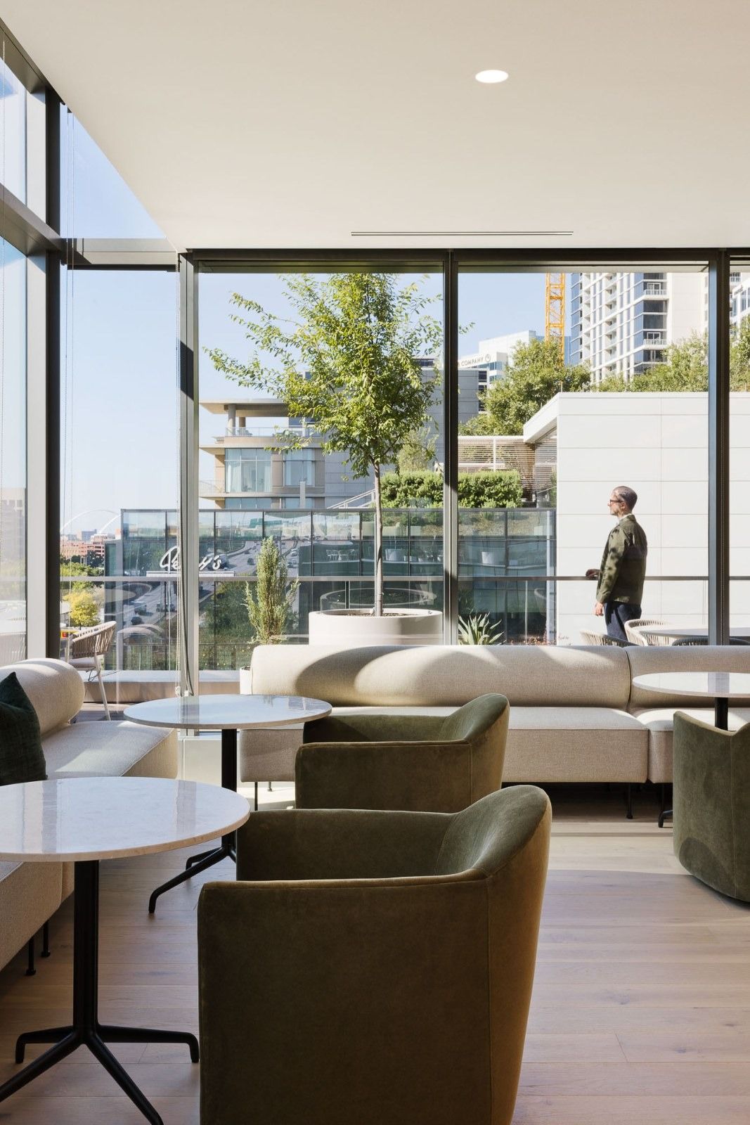 CBRE: Lounge chairs by tall windows with a tree outside