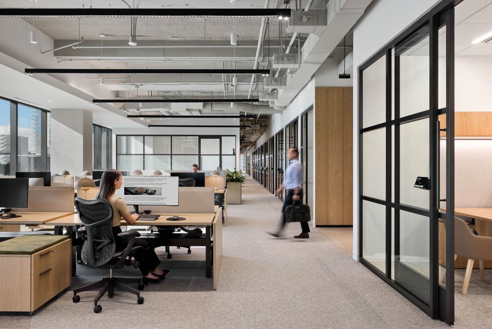 CBRE: Rows of desks with black task chairs under an open ceiling