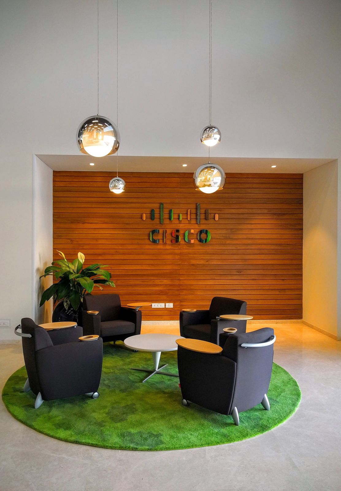 Cisco: A lounge with a green rug in Cisco Bangalore