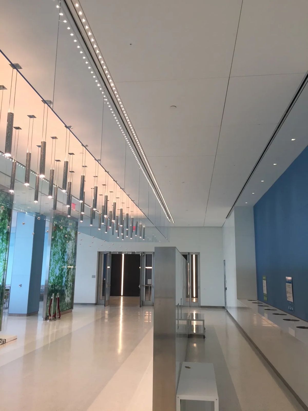 Citigroup: Long hall with a lit slatted ceiling and a blue wall