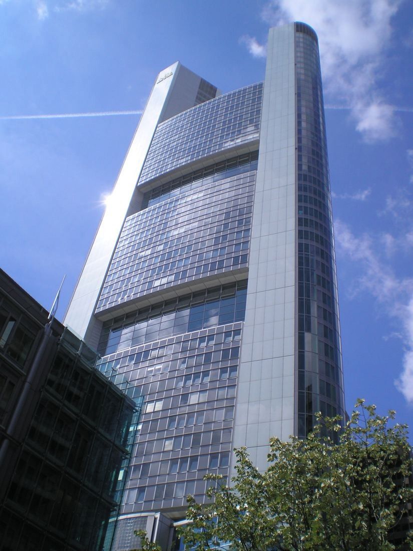 Commerzbank: Angled view up the glass and steel facade of the tower against a blue sky
