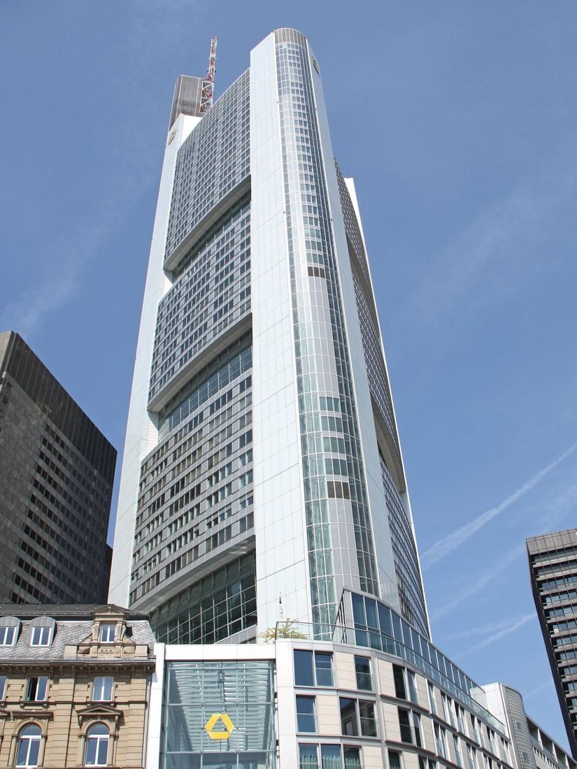 Commerzbank: Close view up the curved glass facade of the tower with a lower glass entrance building in front
