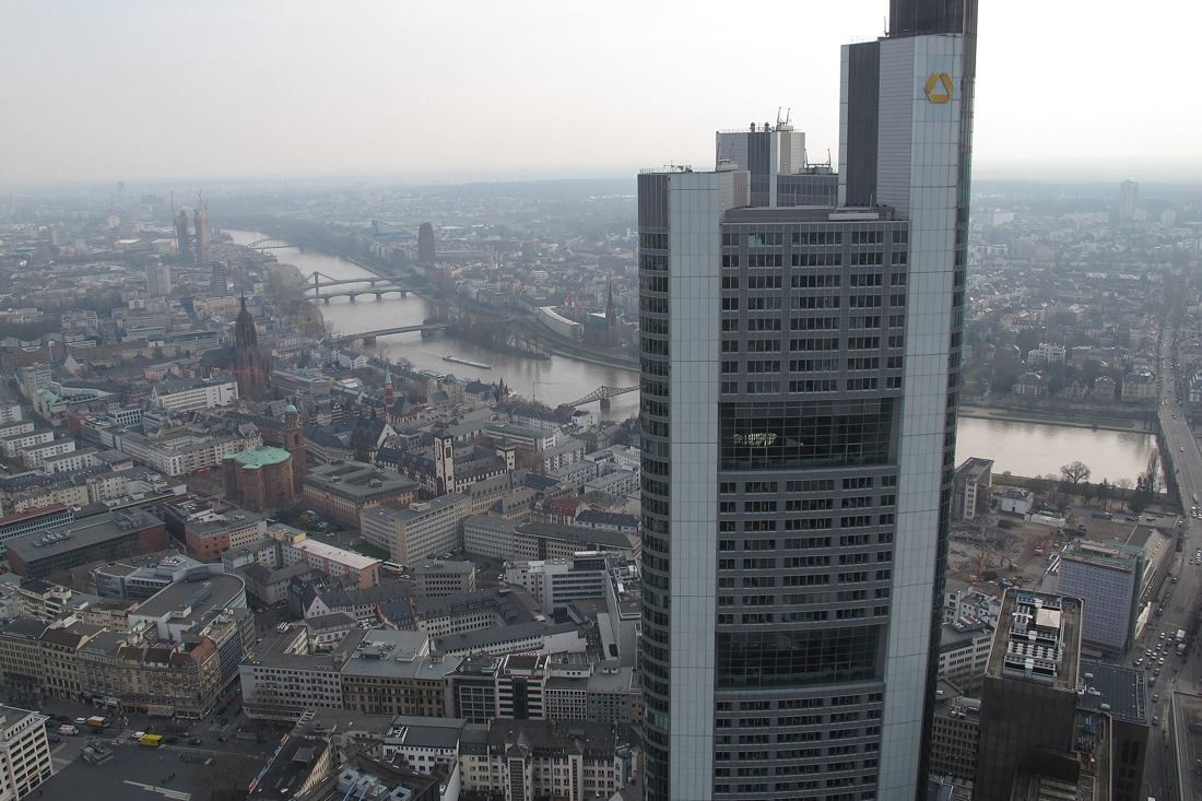 Commerzbank: The upper part of the tower seen at eye level from another high-rise, with the river and old town below