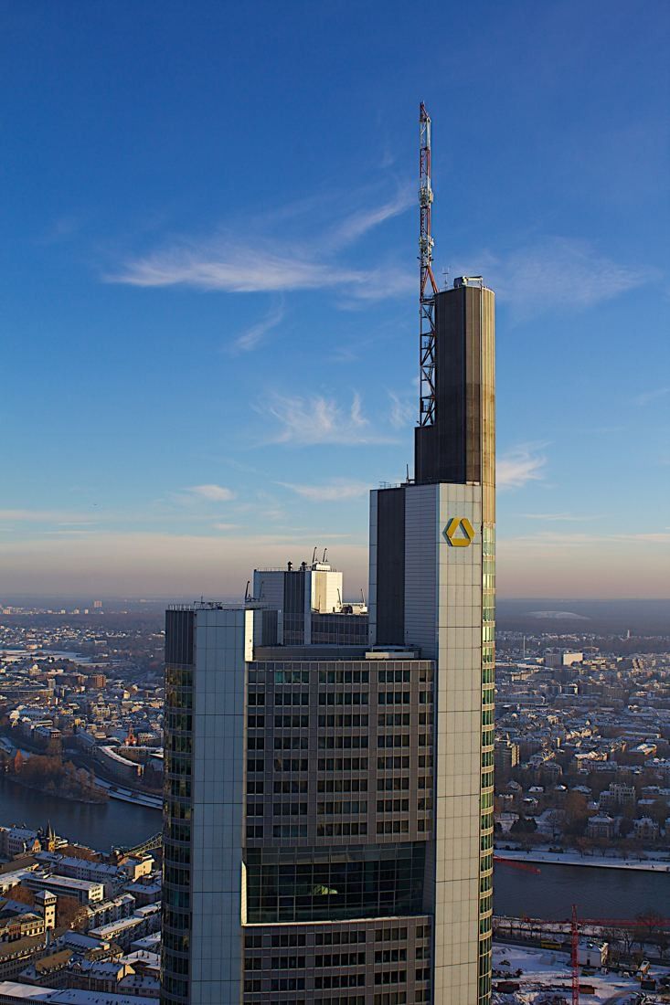Commerzbank: Top of the tower and its mast in low sun with the city and horizon behind
