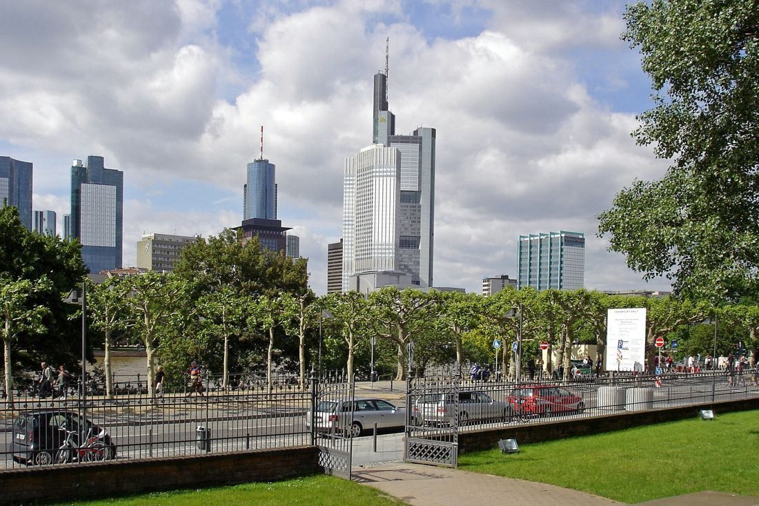 Commerzbank: Tower rising over trees and a park lawn with other high-rises nearby
