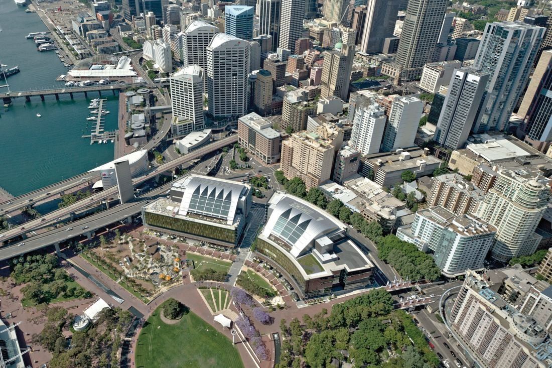 Commonwealth Bank of Australia: Aerial view of two long curved office buildings beside a park, with the city centre and harbour behind