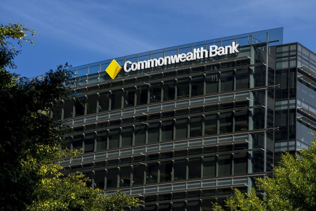 Commonwealth Bank of Australia: Glass office building with horizontal sunshades and a Commonwealth Bank sign on the roofline, trees in front