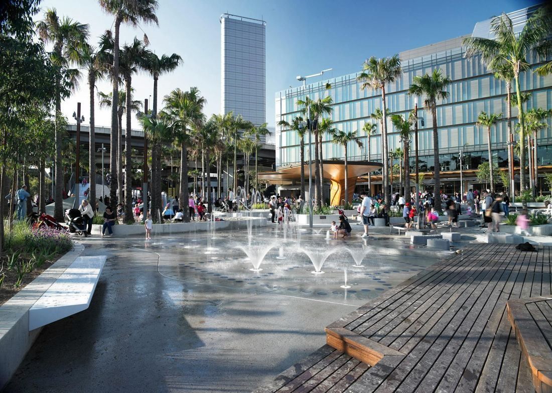 Commonwealth Bank of Australia: Water play fountains and timber decking with palm trees and a glass office building behind
