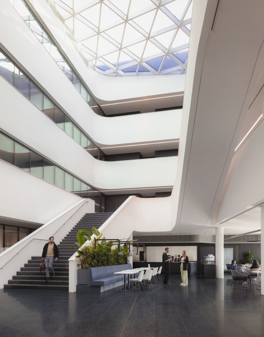 Continental: White atrium under a triangular glass roof with sweeping balconies and a staircase