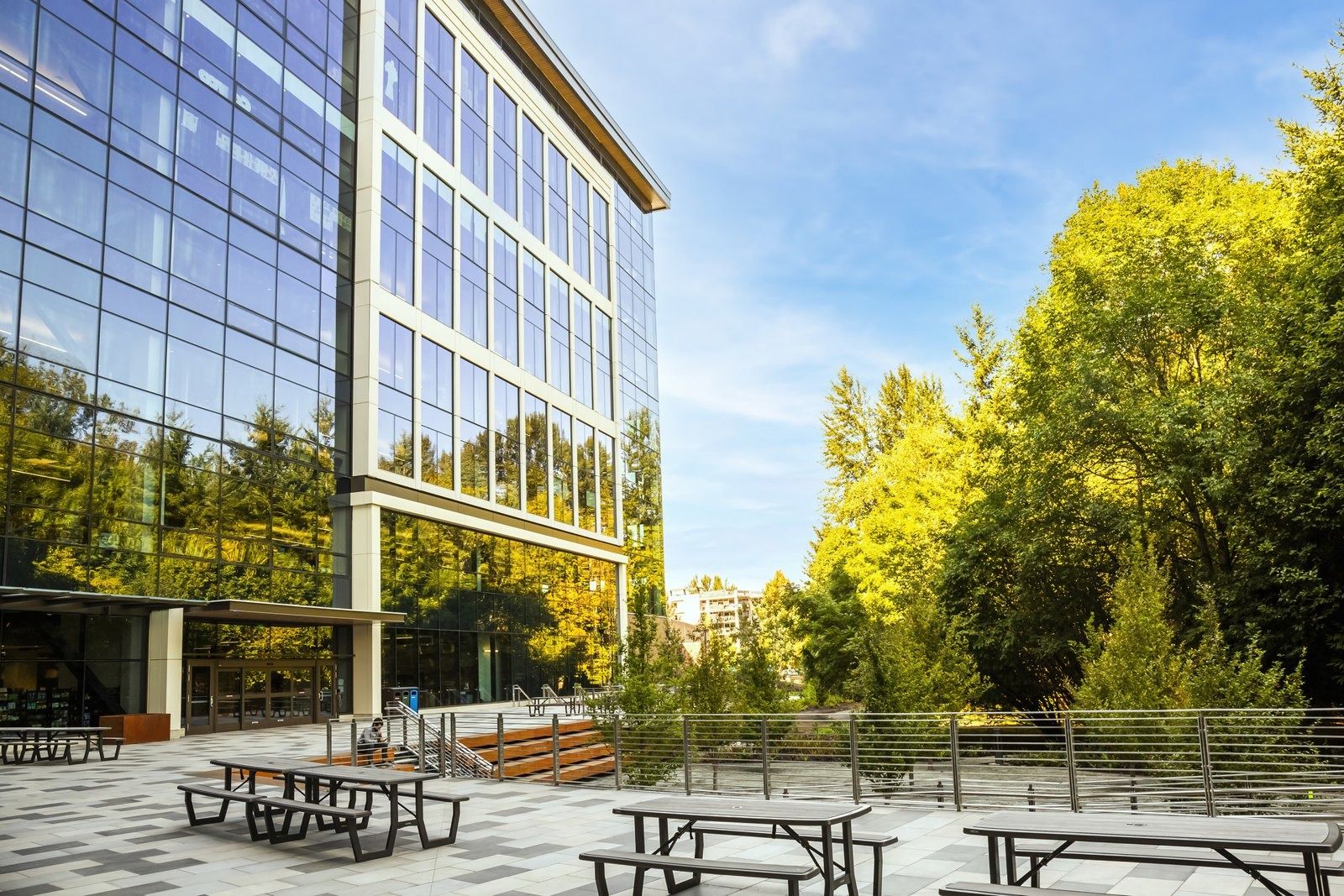 Costco Wholesale: A glass building with picnic tables among trees